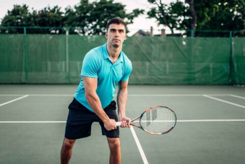 athletic-male-tennis-player-plays-on-outdoor-court-PTFN2XZ